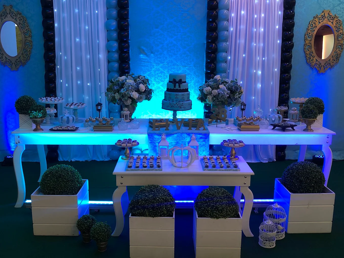 Mesa decorada com iluminação azul, pronta para uma festa adulta