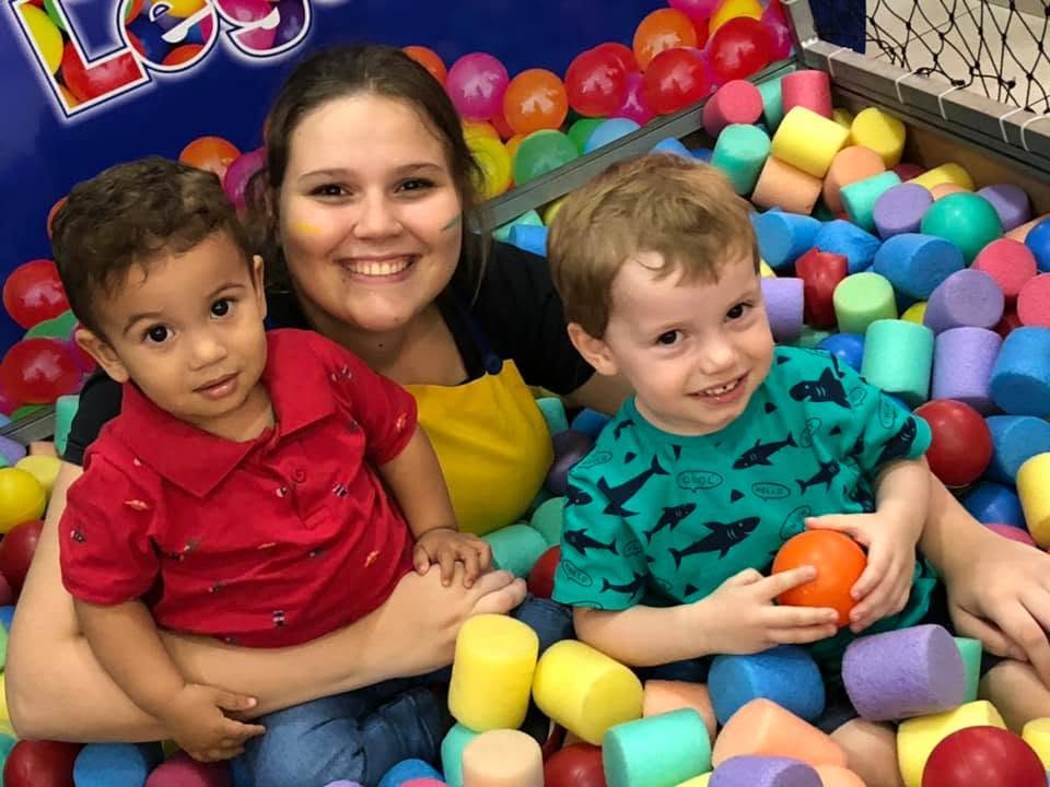 Mãe e duas crianças brincando na piscina de bolinhas durante uma festa no Star Buffet